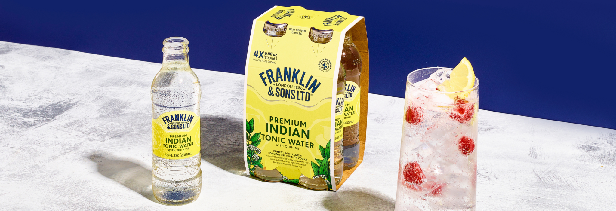 Franklin & Sons Premium Indian Tonic Water with quinine used in a cocktail that has raspberries as the garnish in a highball glass | Franklin & Sons